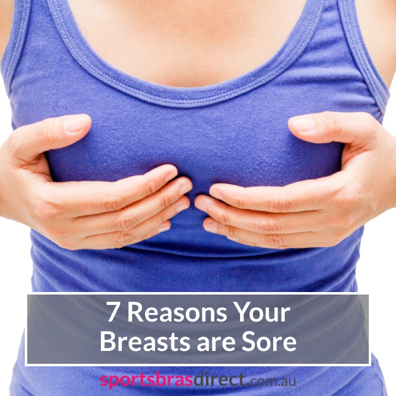 Woman holding her sore breasts.