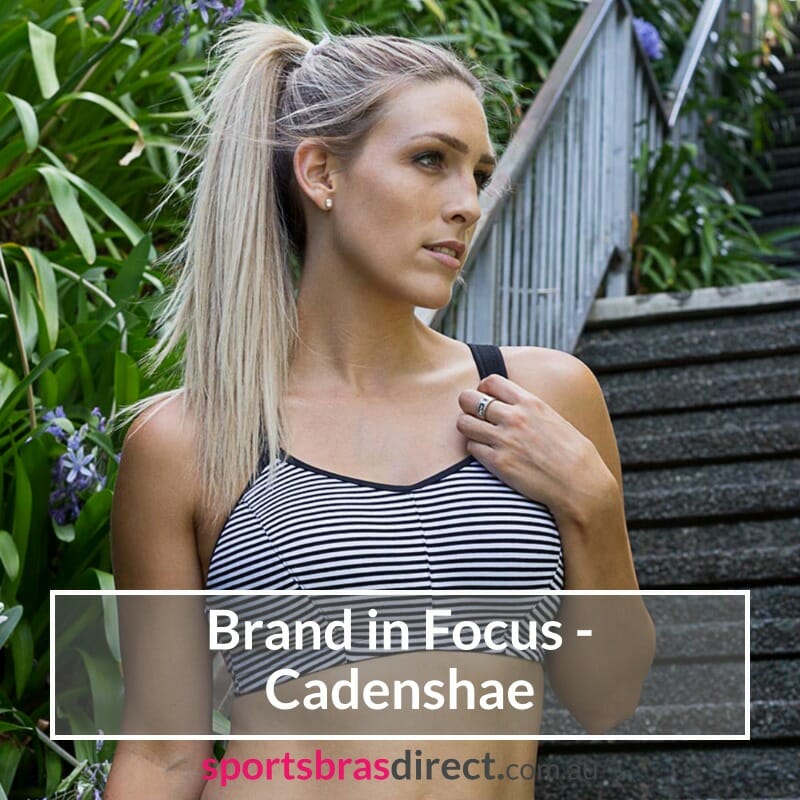 A woman standing in a striped sports bra.