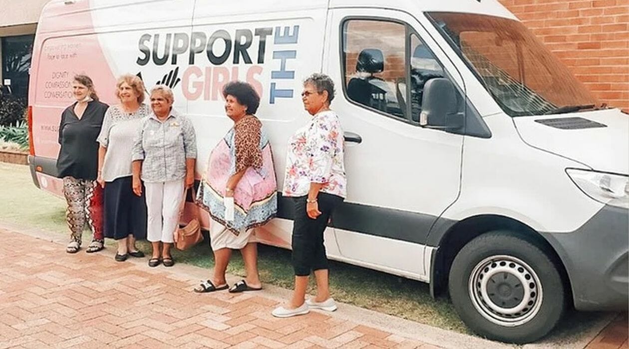 Women standing in front of a White van.