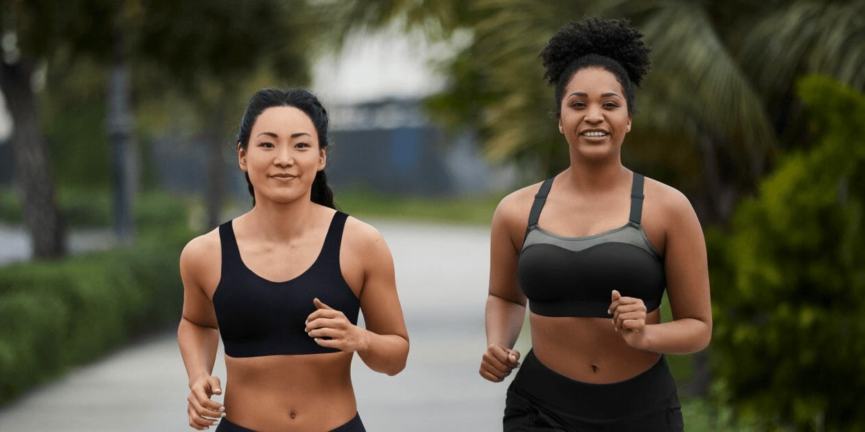 Two women running in sports bras.