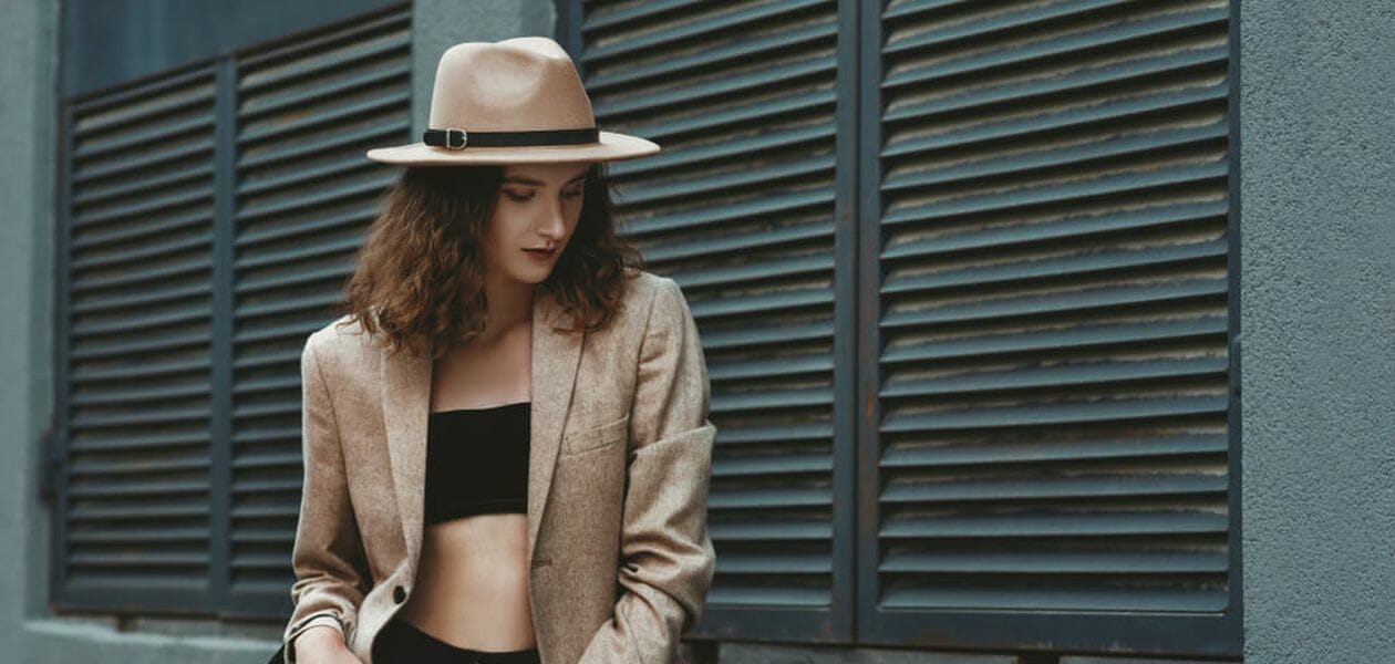 woman wearing black jeans and sports bra topped with light brown blazer