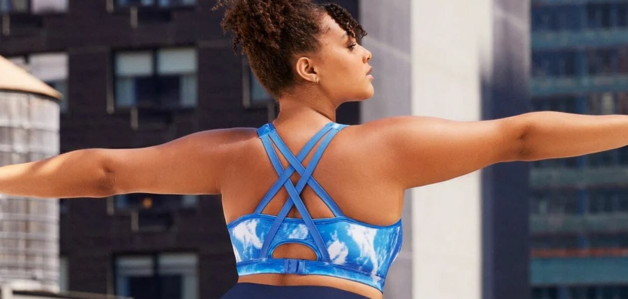 Woman stretching in Blue sports bra.