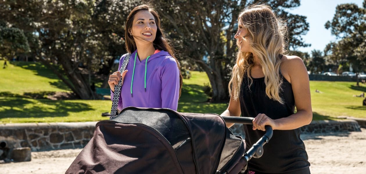 Two women walking a baby in a pram